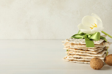 Matzo, nuts and flower on light background, space for text