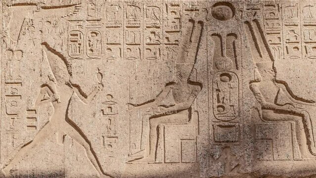 Ancient Egyptian hieroglyphs and bas-reliefs close-up in Luxor Temple, ancient Thebes, Egypt. Luxor Temple is a large Ancient Egyptian temple complex located on the east bank of the Nile River.