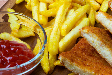 French fries and mirelit meat on a wooden table