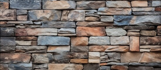 A closeup of a brown stone wall featuring various types of rocks, creating a unique composite material. The rectangular brickwork resembles flooring with a mix of wood and brick