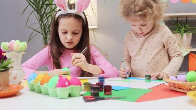 Easter egg decorating. Children get creative with Easter egg dyes. Vibrant egg designs for the holiday. Little siblings painting easter eggs in home interior