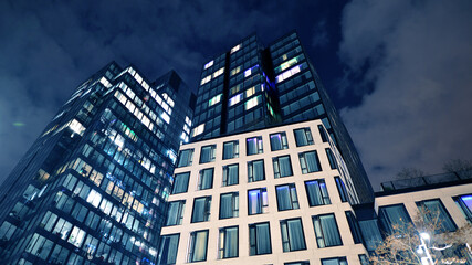 Office building at night, building facade with glass and lights. View with illuminated modern...