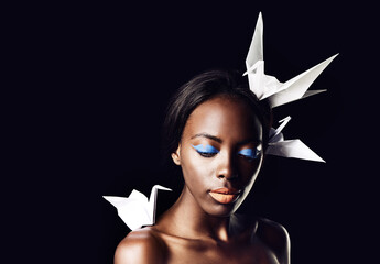 Black woman, makeup and fine art with beauty, dove or origami birds on a dark studio background....
