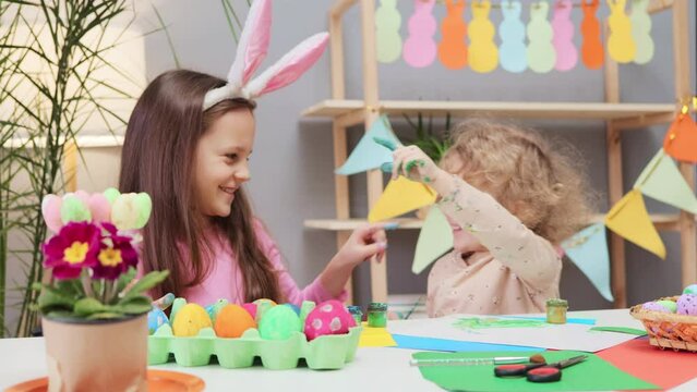 Crafting custom easter eggs. rafting Easter egg delights for kids. Traditional egg dyeing. Cute children painting easter egg preparing for holiday in home interior getting paint on each other's noses
