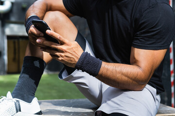 Young Athlete Man Using Smartphone In Gym