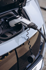 Close up photo of charging electric car with socket