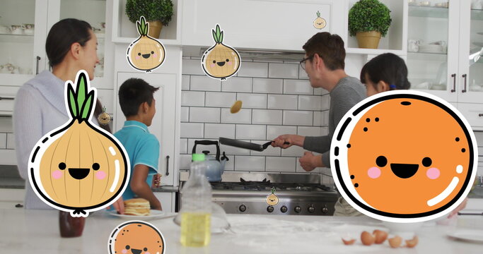 Image of onions and oranges over happy asian family making pancakes in kitchen