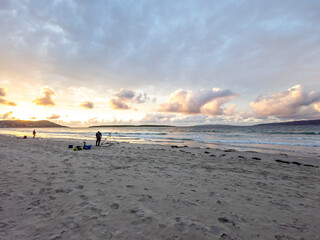 20 man are competing in a fishing competition on the beach.