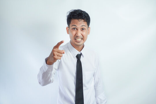 Adult Asian man looking to camera with angry expression while pointing finger forward