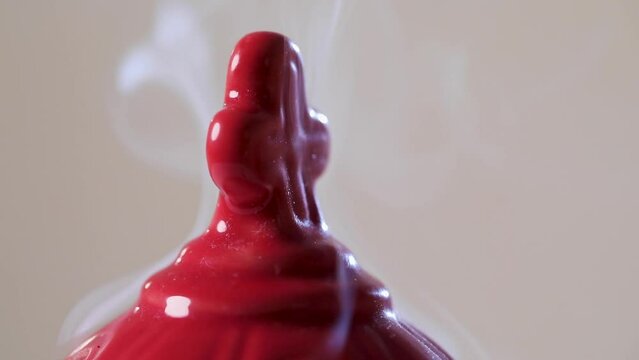 The cross on the red censer, with rising smoke