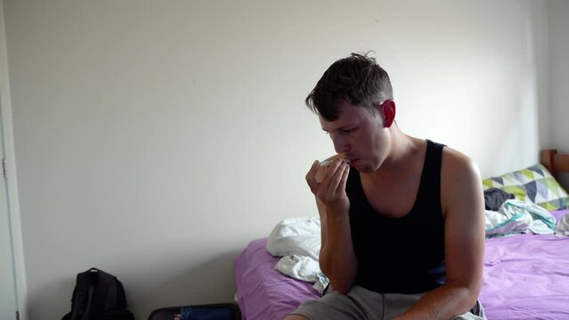 A sick man measuring his fever temperature in the hotel room on vacation.