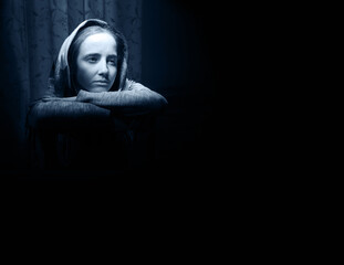 Lone sad pretty girl in dark room