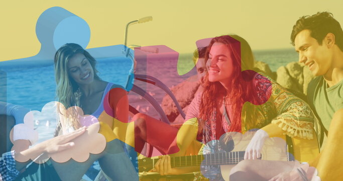 Image of colourful puzzle pieces over happy friends at summer beach party