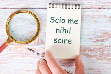 Scio me nihil scire It is translated from Latin as I know I don't know anything. It is written in a...