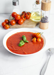 fresh tomato soup in a white bowl. on a white background
Tomato soup with basil and olive oil on a white background.