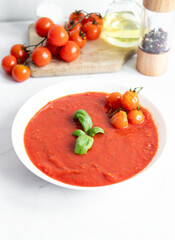 fresh tomato soup in a white bowl. on a white background
Tomato soup with basil and olive oil on a white background.