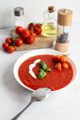 fresh tomato soup in a white bowl. on a white background
Tomato soup with basil and olive oil on a white background.