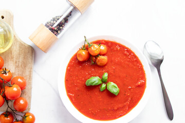 fresh tomato soup in a white bowl. on a white background
Tomato soup with basil and olive oil on a white background.