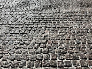 Cobblestone stone pavement road gray background.