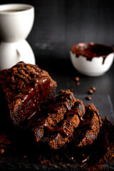 
Chocolate cake with cocoa powder and a cup of coffee. black background. dessert