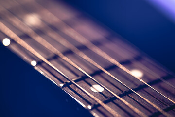 Part of an acoustic guitar, guitar fretboard on a black background.