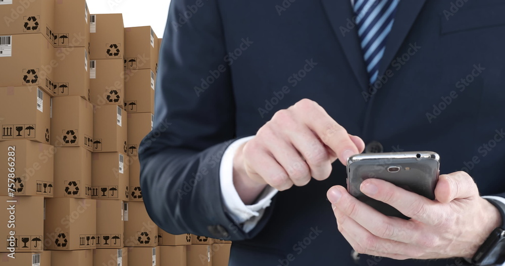 Poster image of businessman using smartphone with stacks of boxes on white background