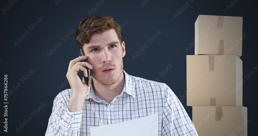 Poster image of man talking on smartphone with stack of boxes on blue background