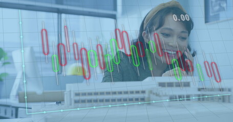 Image of financial data processing over asian businesswoman working at office