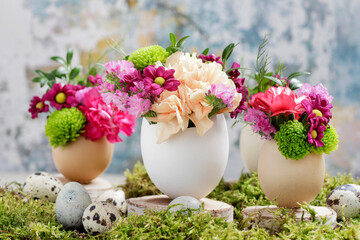 Florist at work: woman shows how to make simple Easter decoration with egg shell and various flowers.