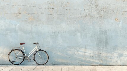 Freedom and simplicity in transportation are symbolized by a solitary bicycle leaning against a plain wall