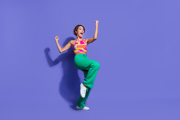 Photo of joyful positive cheerful woman wear trendy clothes look empty space shout hooray glad triumph isolated on purple color background