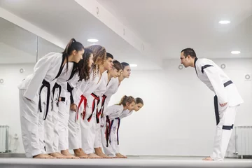 Gordijnen Taekwondo kids are bowing to their coach at martial art school. © dusanpetkovic1