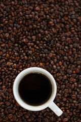 A cup of coffee with coffee beans.