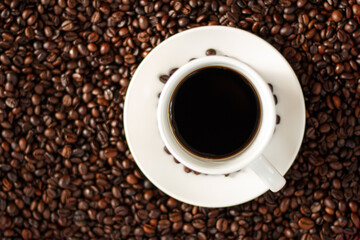 A cup of coffee with coffee beans.