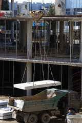loading concrete blocks onto a truck using a crane at a modern construction site