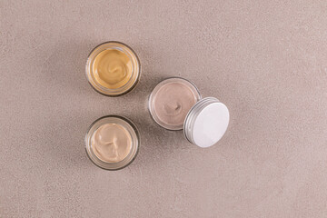 A set of glass jars with cosmetic cream of different colors for face and body skin care. Design. packaging. Product presentation. Top view. mockup.