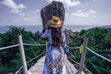 Asian woman tourist  sightseeing and enjoying the view of overlap stone at Samui island in Thailand.