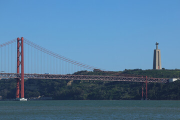 25 April Bridge and the statue of Jesus over Tagus River. Landmarks from Lisbon, Portugal, during a...