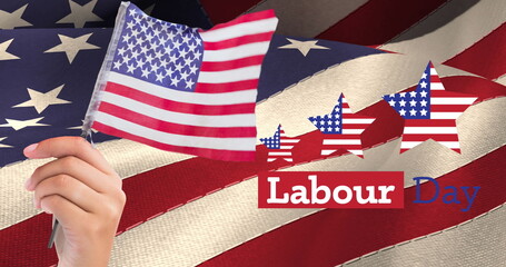 Image of labor day text with american flag stars and hand holding flag, over american flag