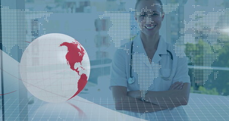 Image of globe and world map over caucasian female doctor at hospital