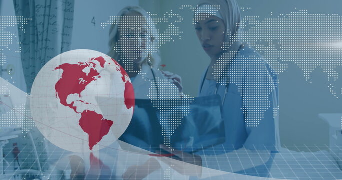 Image of globe and world map over diverse doctors at hospital