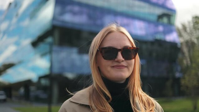 Portrait of gorgeous smiling Caucasian young woman in formal suit in sunglasses looking to camera outside on street feel happy businesswoman 