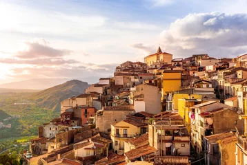 Zelfklevend Fotobehang old vintage mediterranean mountain town with yellow and orange roofs, old tradirional streets, churches and amazing cloudy landscape on background © Yaroslav