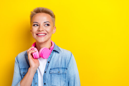 Photo portrait of attractive young woman headphones look empty space dressed stylish denim clothes isolated on yellow color background