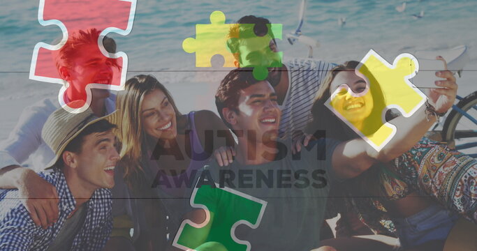 Image of colourful puzzle pieces and autism text over happy friends at summer beach party
