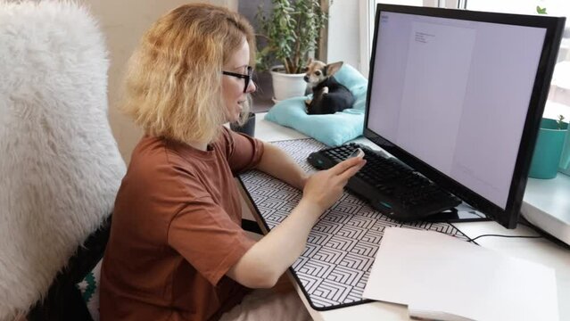 Working remotely, woman at desk with her dog, online job, home office