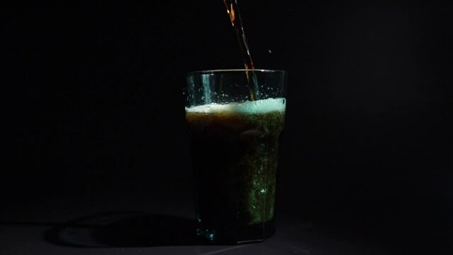 Cola is poured into a glass, refreshing soda, fizzy splash
