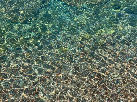 Sea underwater clear water with pebbles stones on seabed. 