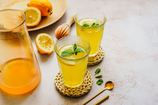 Sommer Getränk mit Zitrone in zwei Gläsern auf einem grauen Tisch. Erfrischung.