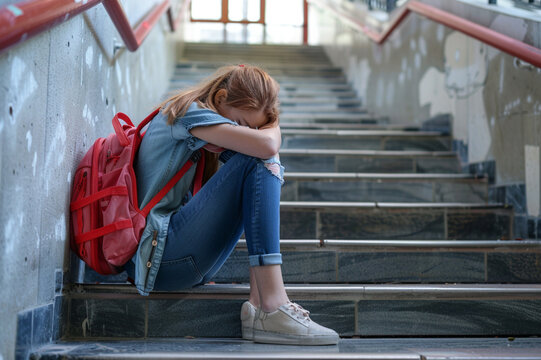 Depression in school - sad girl sitting on the stair 